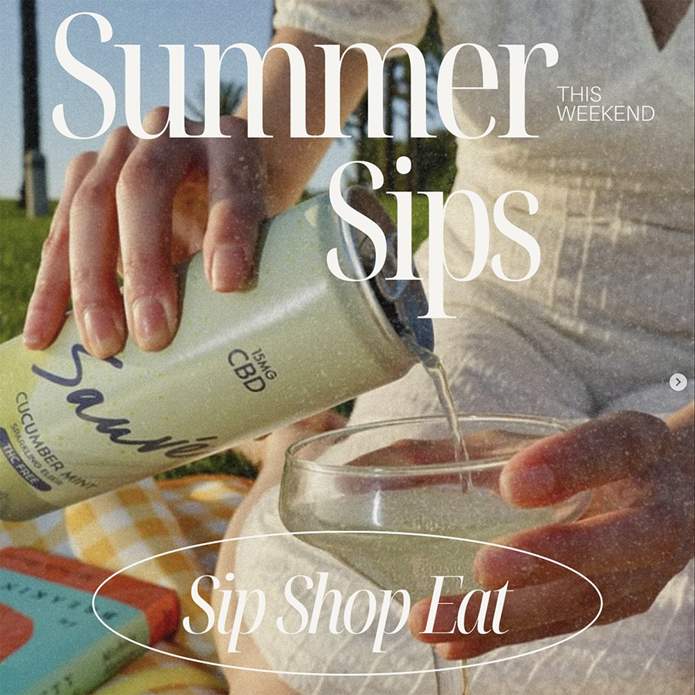 A person wearing white and sitting on a picnic blanket, pouring a 12oz can of Cucumber Mint Sparkling Elixir into a martini glass. White text overlay reads: "Summer Sips This Weekend; Sip Shop Eat"